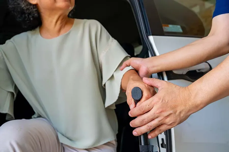 Chauffeur de taxi aidant une femme à sortir du véhiculwebp